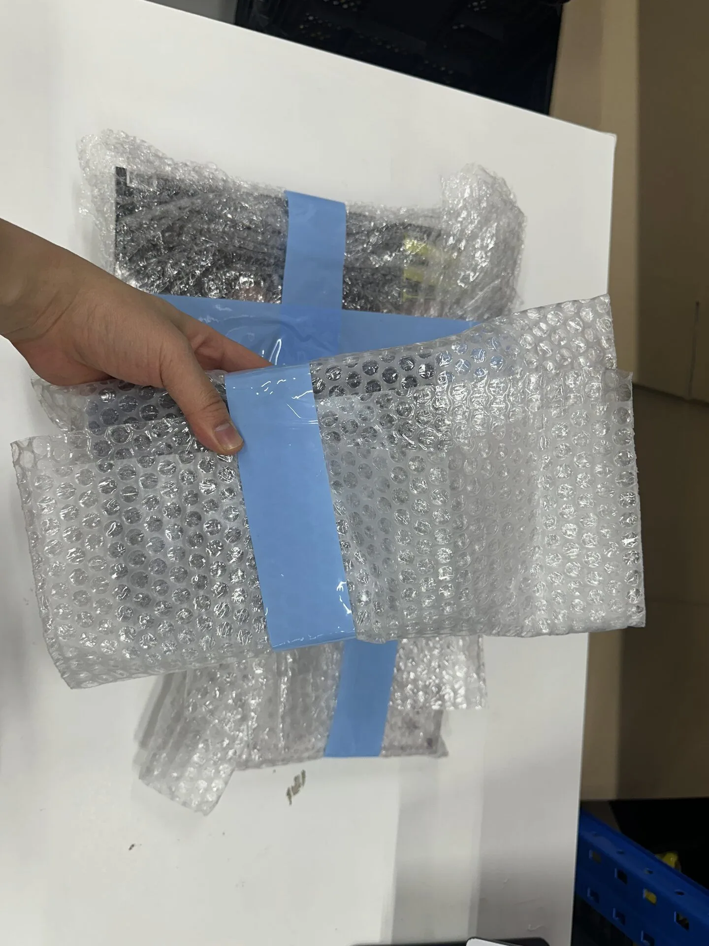 Bubble-wrapped K-pop products inside an opened delivery box