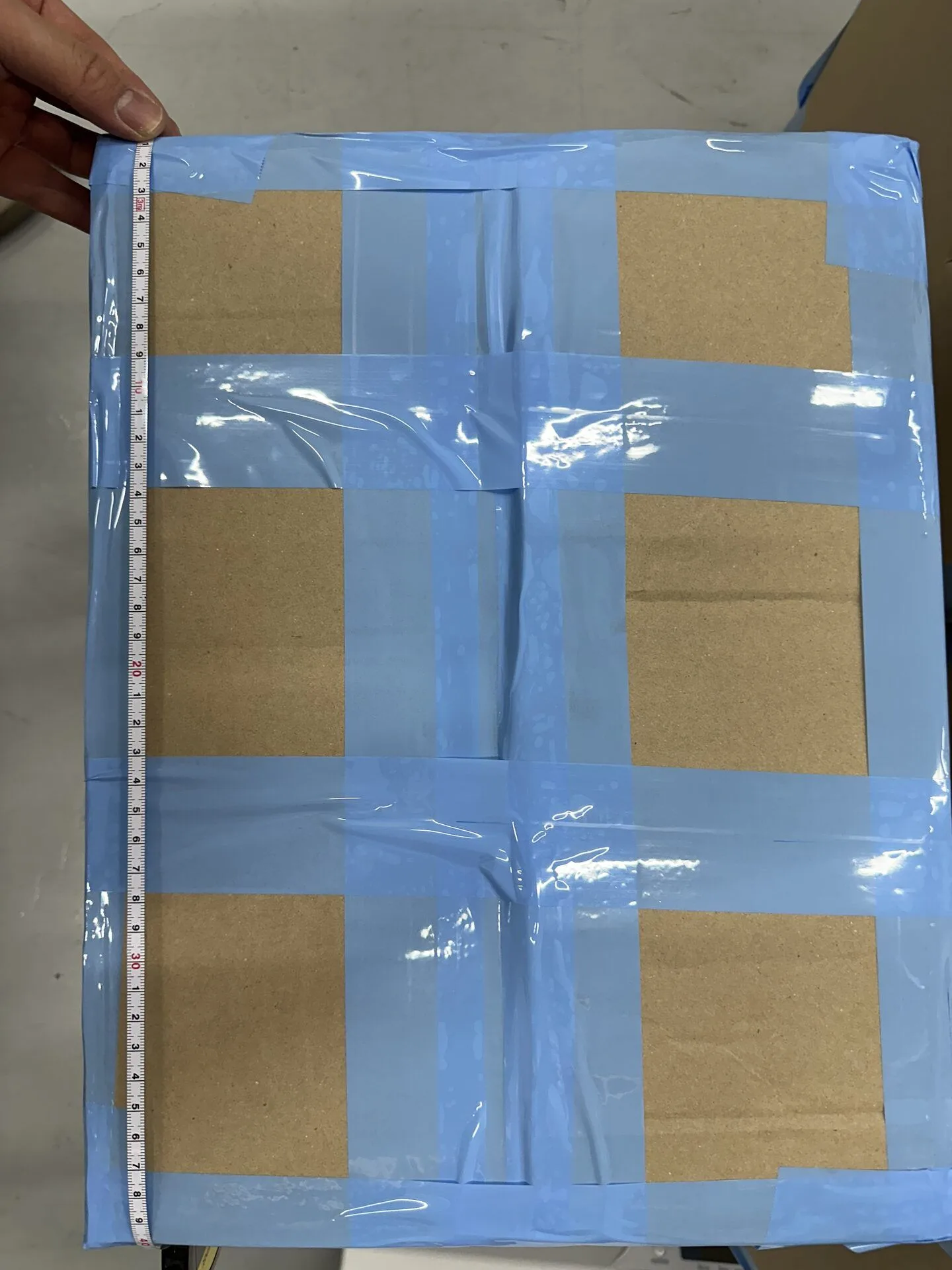 Measuring the length of a packed K-pop shipment carton